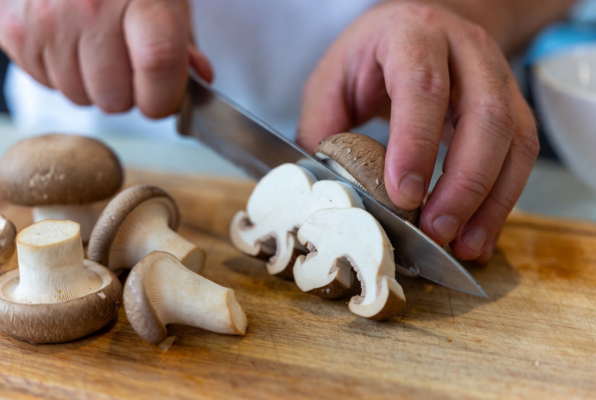 Preparing king oyster mushrooms by slicing into vegan scallop medallions