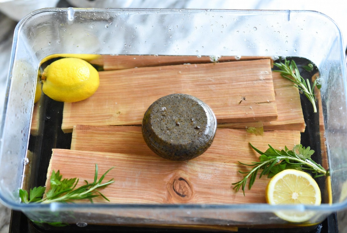 Soaking cedar planks in water before grilling for moisture and safety